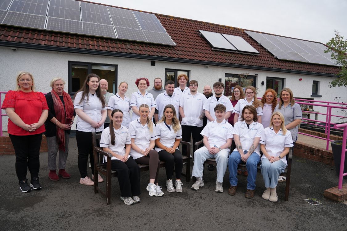 Group of students in pharmacy tunics with lecturers outside SERC's Holywood Campus